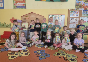 Dzieci z upominkami pozują do zdjęcia grupowego