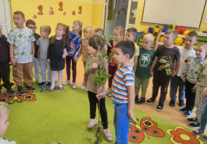 Dzieci robią koło wokół sadzonki drzewa