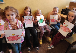 Dzieci pokazują pomalowane "Świnki-skarbonki"