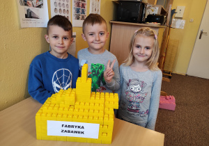 Dzieci ze swoją budowlą z klocków - fabryką zabawek
